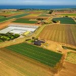 Aerial scenery of agricultural fields near ocean coastline in Australia - optimised