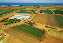 Aerial scenery of agricultural fields near ocean coastline in Australia - optimised