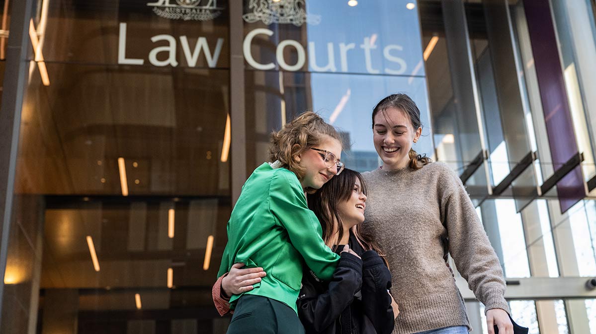 High School students Ava Princi, Izzy Raj-Seppings and Laura Kirwin embrace outside The Federal Court of Australia in Sydney. (AAP Image/James Gourley)