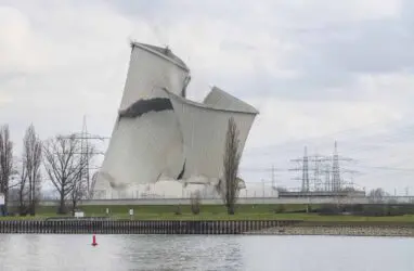 The second of the four cooling towers of the decommissioned Biblis nuclear power plant is collapsing as planned during demolition in Biblis, Germany, Thursday, Feb. 23, 2023. It was not blown up, but destabilized with excavators until it collapsed. The nuclear power plant was decommissioned following Germany's nuclear phase-out in the wake of the Fukushima disaster in 2011. (Frank Rumpenhorst/dpa via AP)