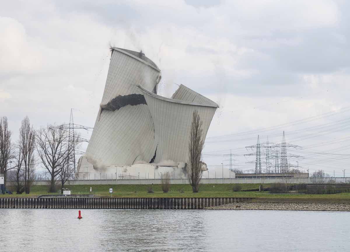 The second of the four cooling towers of the decommissioned Biblis nuclear power plant is collapsing as planned during demolition in Biblis, Germany, Thursday, Feb. 23, 2023. It was not blown up, but destabilized with excavators until it collapsed. The nuclear power plant was decommissioned following Germany's nuclear phase-out in the wake of the Fukushima disaster in 2011. (Frank Rumpenhorst/dpa via AP)