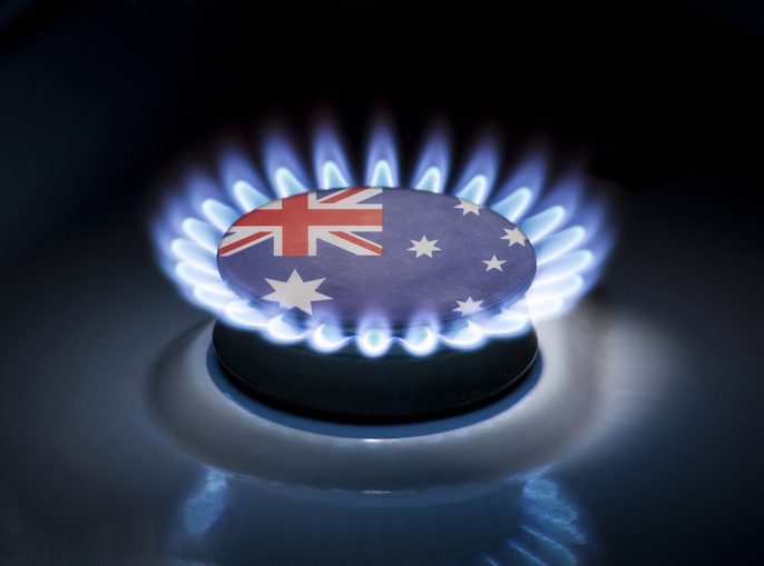 Burning gas burner of a home stove in the middle of which is the flag of the country of Australia. Gas import and export delivery concept, price per cubic meter, transit, background